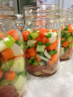 several jars filled with different types of vegetables