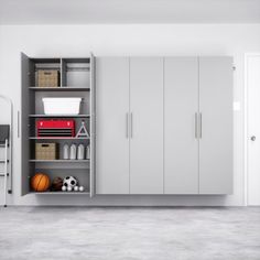 an empty room with white cabinets and sports equipment