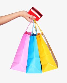 a person's hand holding several colorful shopping bags