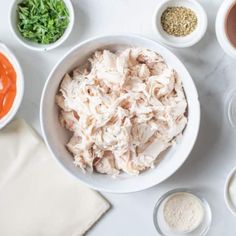 bowls filled with different kinds of food on top of a white countertop next to sauces and seasonings