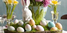 a basket filled with eggs and flowers on top of a table