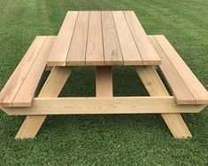 a wooden picnic table sitting in the grass