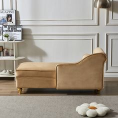 a beige couch sitting on top of a wooden floor next to a white book shelf