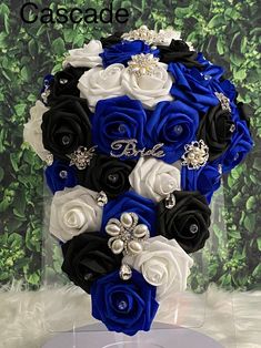 a bridal bouquet in blue, white and black with crystal brooches on it