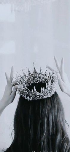 a woman wearing a tiara with her hands up to her face and the crown on her head