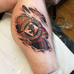 a man's leg with a tattoo on it that has the words scotland and an image of a lion