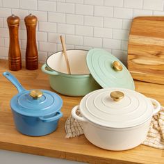 several pots and pans sitting on a counter top next to wooden utensils