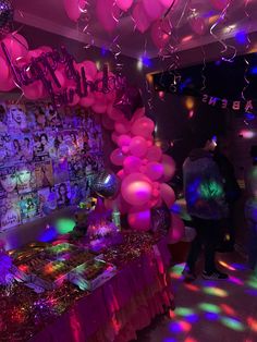 a party with balloons, streamers and pictures on the wall is lit up at night