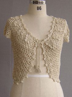 a white mannequin wearing a crochet top