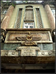 an old building with ornate carvings on the front and side windows, along with a plaque that reads