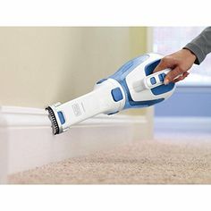 a person using a handheld vacuum to clean carpet