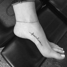 a woman's foot with the word faith written on it and a cross tattoo