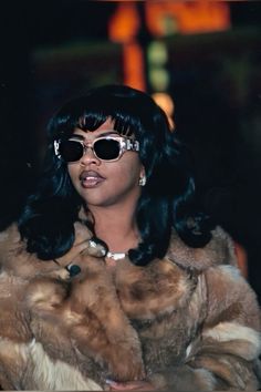 a woman wearing sunglasses and a fur coat