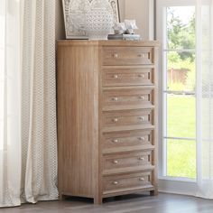 a chest of drawers in front of a window