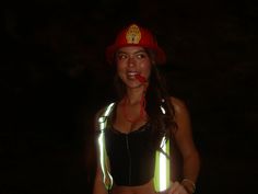 a woman wearing neon vests and a fireman's hat