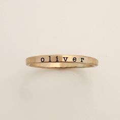 a gold ring with the word oliver engraved on it's side, against a white background