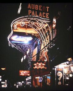 the neon sign for albert palace is lit up at night