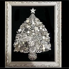 a christmas tree made out of buttons in a silver frame on a black background with an ornate border around it