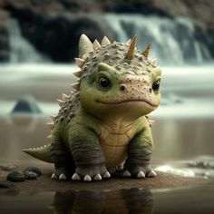 a small toy dinosaur sitting on top of a sandy beach next to a waterfall and rocks