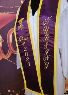 a purple and yellow graduation stole with gold lettering