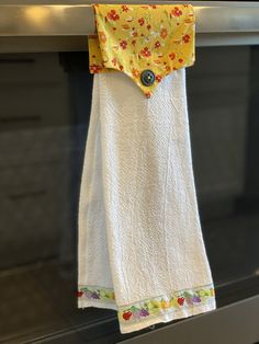 a yellow and white towel hanging on a clothes line in front of an oven door