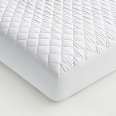 an image of a mattress topper on a white bedding set that looks like it's made out of quilts