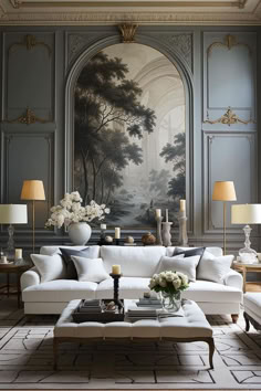 a living room filled with white furniture and paintings on the wall above it's fireplace