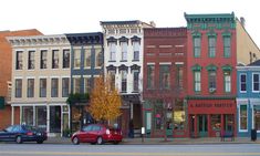 several buildings line the street in front of each other on a city street with parked cars