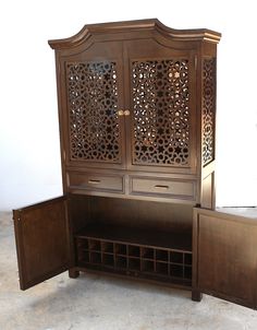 an ornate wooden cabinet with wine bottles in it