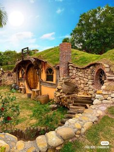 an image of a hobbot house in the middle of grass and rocks with stairs leading up to it