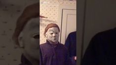 a man wearing a creepy mask in front of a mirror