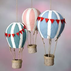 three hot air balloons are hanging from twine