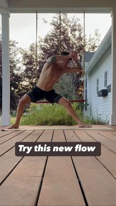 the man is practicing his yoga moves on the wooden deck in front of the house