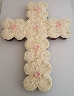 a cross made out of cupcakes sitting on top of a white tablecloth