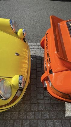 two orange cars parked next to each other