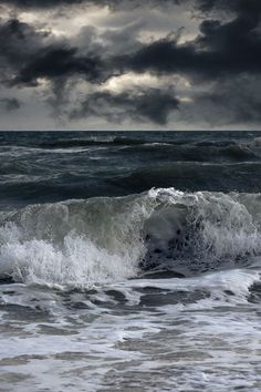 an ocean scene with dark clouds and waves