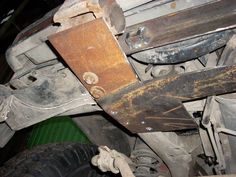 an old rusted metal object sitting on top of a green floor next to a tire