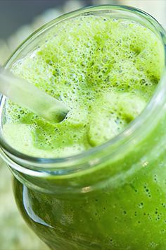 a green smoothie in a mason jar with a straw sticking out of the top