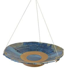 a blue bowl hanging from a metal hook