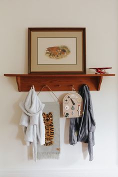 there is a clock and towels hanging on the wall next to a towel rack with an animal print