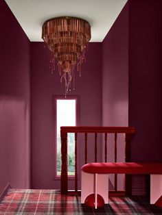 a room with purple walls and a red bench in the corner, along with a plaid rug on the floor