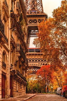 the eiffel tower towering over an old street in paris, france during autumn