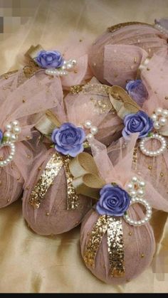 several pink and blue flowers are on top of some fabric balls with gold sequins