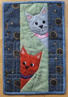 a close up of a quilt with two cats on it