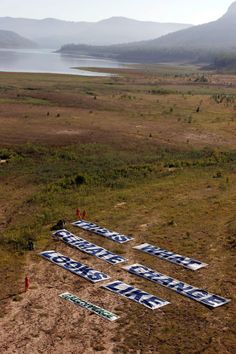 there are many signs that have been placed on the ground in front of some water