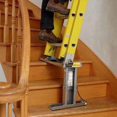 a man is climbing up the stairs with his foot on a stepladder and using a handrail