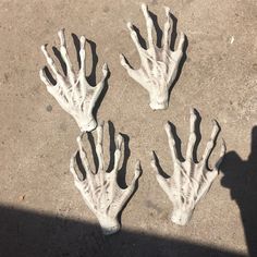 four fake hands are placed on the ground in front of a person's shadow