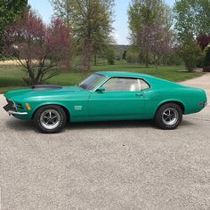 a green muscle car parked in a parking lot