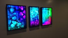 three colorful paintings hanging on the wall next to each other