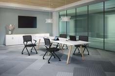 an empty conference room with chairs and a table in front of a flat screen tv